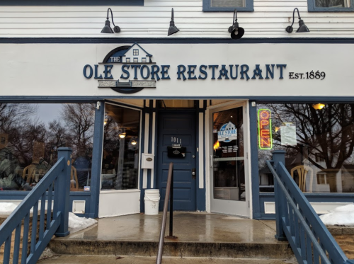 Front view of Ole Store Restaurant, established 1889, featuring a blue door and an "Open" sign in the window.