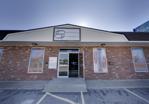 Exterior of Biomes Marine Biology Center, featuring a brick facade and large windows with aquatic-themed images.