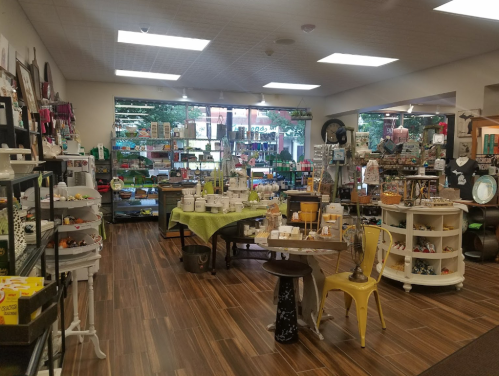 A cozy shop interior filled with various home decor items, crafts, and colorful displays on shelves and tables.