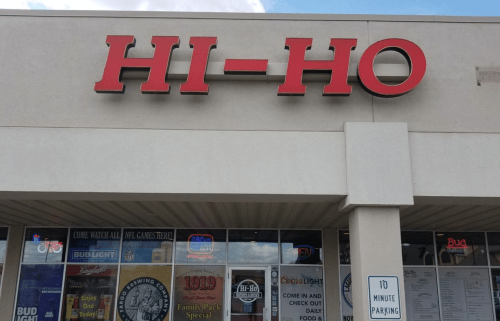 Signage of "HI-HO" restaurant with promotional banners and a 10-minute parking sign in front.
