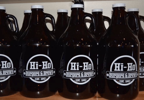 A row of dark glass growlers labeled "Hi-Ho Burgers & Brews" with an established date of 1947.