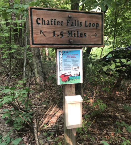 Sign for Chaffee Falls Loop trail, indicating a distance of 1.5 miles, surrounded by trees and nature.