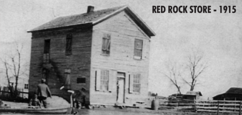Historic photo of the Red Rock Store from 1915, featuring a two-story wooden building and a person outside.