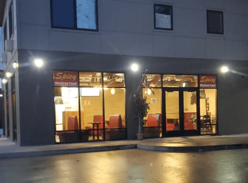 Exterior of a restaurant named "Spicy Mexican Food," featuring large windows and a modern building design.