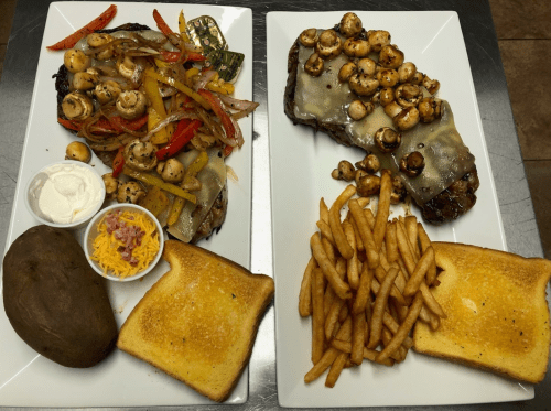 Two plates of food: one with grilled steak topped with mushrooms and cheese, the other with a baked potato, fries, and toast.