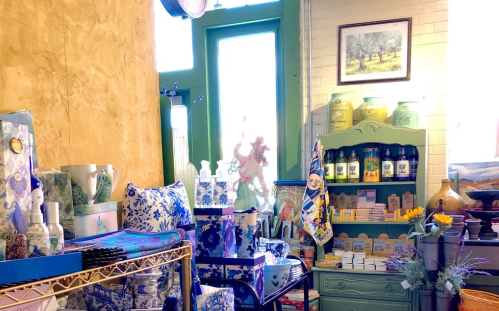 A cozy shop interior filled with blue and white decor, vintage items, and shelves of various products.