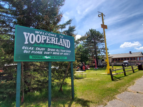 Sign welcoming visitors to Yooperland, with playful instructions and a scenic outdoor setting.
