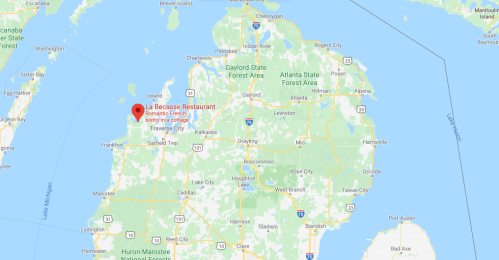 Map showing northern Michigan with a red marker indicating the location of La Bécasse Restaurant near Traverse City.