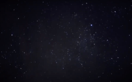 A dark night sky filled with countless stars twinkling against a deep black background.