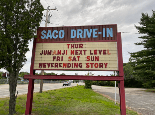 Sign for Saco Drive-In listing movie showings: "Jumanji Next Level" on Thursday, "NeverEnding Story" on Friday to Sunday.