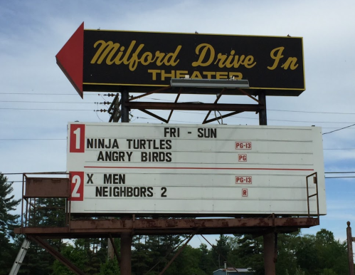 Sign for Milford Drive-In Theater listing movies: "Ninja Turtles," "Angry Birds," "X-Men," and "Neighbors 2."
