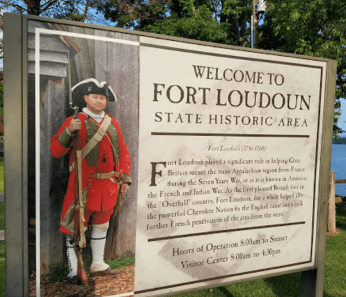 Sign welcoming visitors to Fort Loudoun State Historic Area, featuring historical information and a soldier in period attire.