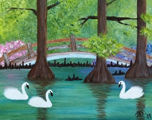 A serene landscape featuring three swans on a tranquil pond, with trees and a bridge in the background.