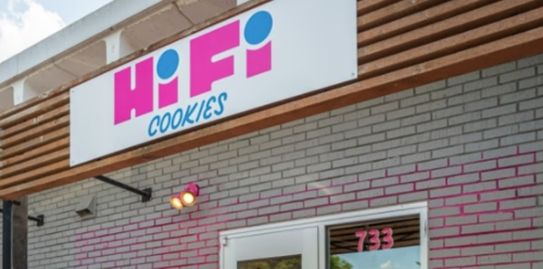Sign for HiFi Cookies on a building with a gray brick facade and pink accents.