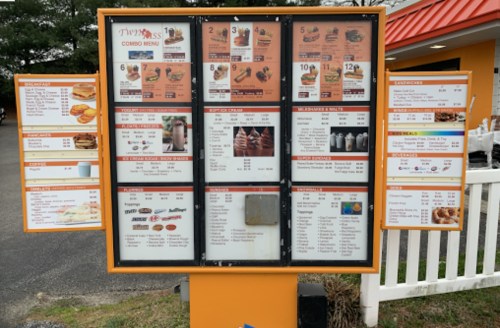 Menu board displaying various food and drink options, including combos, sandwiches, and desserts.