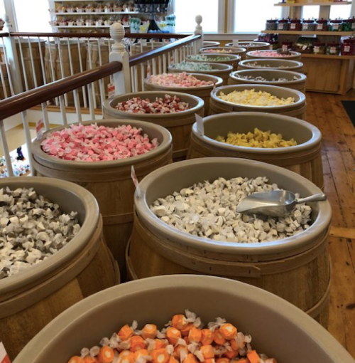 Colorful candy bins filled with various sweets in a charming shop, showcasing a variety of pastel and bright colors.