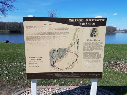 Sign for the Mill Creek Herbert Hoover Trail System, featuring a map and information about the trail and Herbert Hoover.