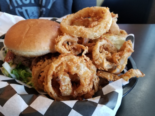 A plate featuring a burger with lettuce and a generous serving of crispy onion rings.
