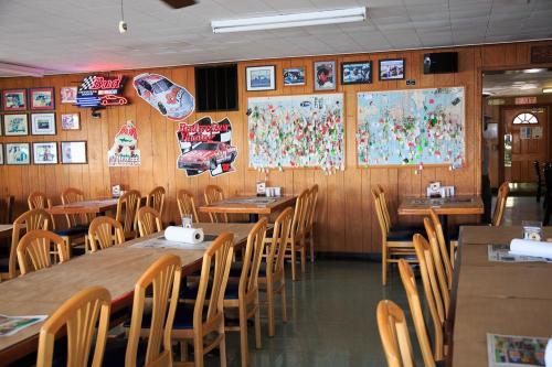Interior of a casual dining restaurant with wooden walls, tables, and racing-themed decor, including maps and photos.