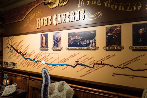 A wall display map of Home Caverns, highlighting various attractions and features within the cave system.