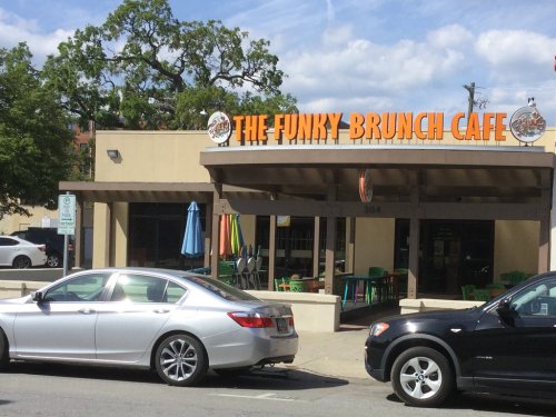 Exterior of The Funky Brunch Cafe with a silver car parked outside and colorful outdoor seating.