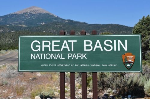 Sign for Great Basin National Park with mountains in the background and clear blue sky.