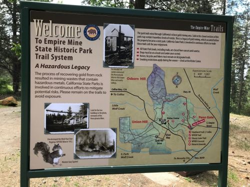 Signboard introducing Empire Mine State Historic Park Trail System, highlighting its history and hazardous legacy.