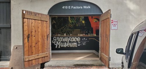 Entrance to the Graverace Museum, featuring wooden doors and a colorful mural inside. Address: 410 E Factors Walk.
