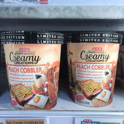 Two tubs of H-E-B Creamy Creations Peach Cobbler ice cream, featuring a bear and a peach cobbler design on the packaging.