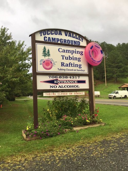 Sign for Toccoa Valley Campground, featuring information on camping, tubing, and rafting, with a pink inner tube decoration.