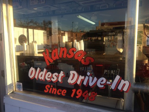 Sign in a window reads "Kansas - Oldest Drive-In Since 1948," with reflections of the surrounding area visible.