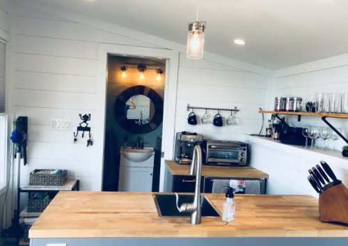 Bright, modern kitchen with wooden countertops, stainless steel appliances, and a cozy, minimalist design.