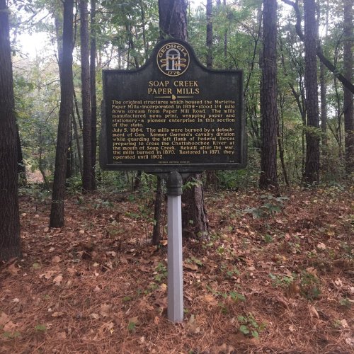 Historical marker for Soap Creek Paper Mills, detailing its history and significance in a wooded area.