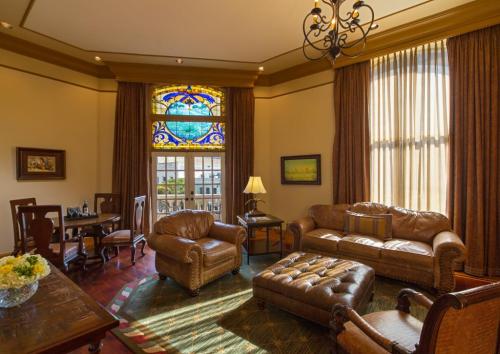 Elegant living room with stained glass window, plush furniture, and warm lighting, creating a cozy atmosphere.