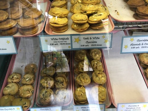 A display case filled with various cookies, including white originals and dark & white chocolate varieties.