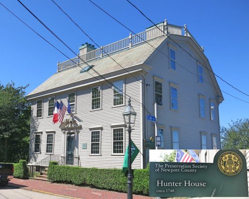 Historic Hunter House in Newport, Rhode Island, featuring a green sign and flags, under a clear blue sky.