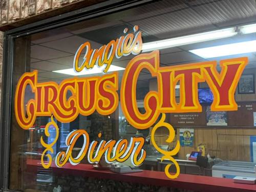 Sign for Angie's Circus City Diner, featuring bold, colorful lettering on a window.