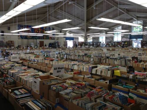 A spacious bookstore filled with rows of boxes containing various books, organized by category.