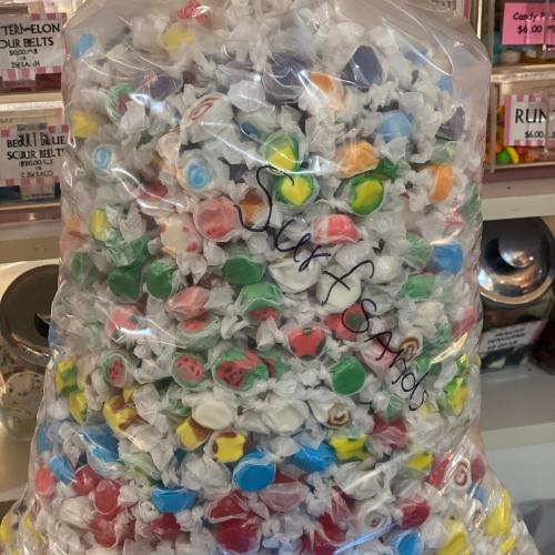 A large bag filled with colorful, assorted candies wrapped in clear plastic.