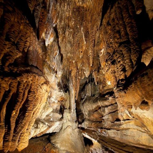 A stunning view of a cave interior, featuring intricate rock formations and dramatic lighting.