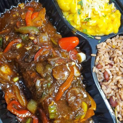 A meal featuring a savory beef dish with peppers, macaroni and cheese, and seasoned rice with beans.