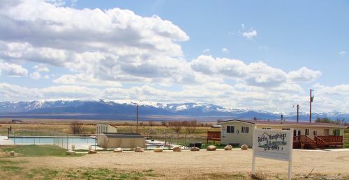 A scenic view of a pool area with mountains in the background under a partly cloudy sky.