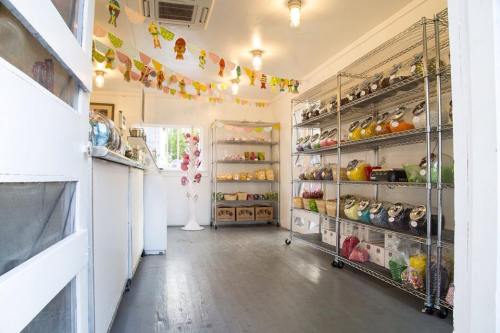 A colorful candy shop interior with shelves filled with jars of sweets and festive decorations hanging from the ceiling.