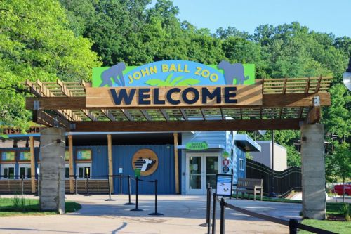 Entrance to John Ball Zoo featuring a large "WELCOME" sign and surrounding greenery.