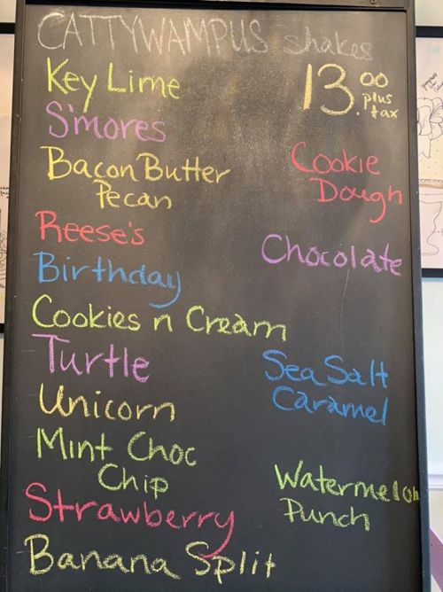 Chalkboard menu listing various milkshake flavors, including Key Lime, S'mores, and Cookie Dough, priced at $13 plus tax.