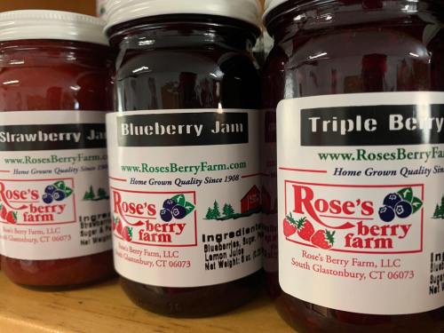Three jars of jam labeled Strawberry, Blueberry, and Triple Berry from Rose's Berry Farm, showcasing homegrown quality.