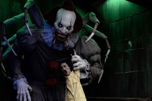 A creepy clown with spider-like features looms over a terrified child in a dark, eerie setting.