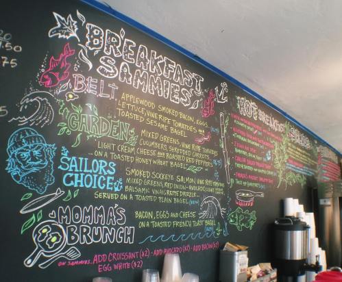 Chalkboard menu featuring breakfast sandwiches, ingredients, and options like "Momma's Brunch" and "Sailor's Choice."