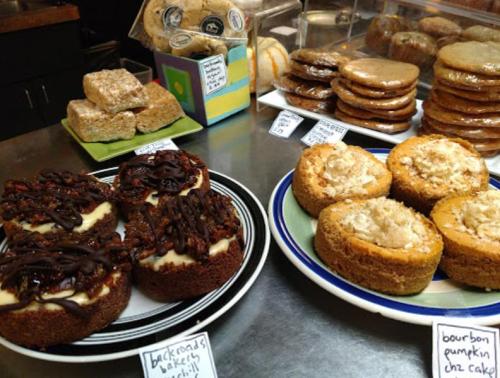 A display of various baked goods, including pumpkin cakes and cookies, arranged on plates and trays.