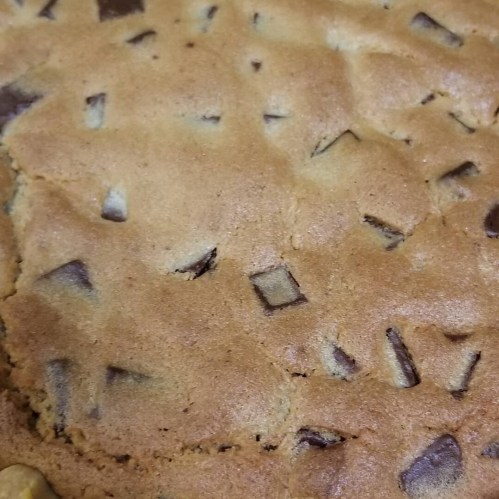 Close-up of a freshly baked cookie with chocolate chunks scattered throughout.